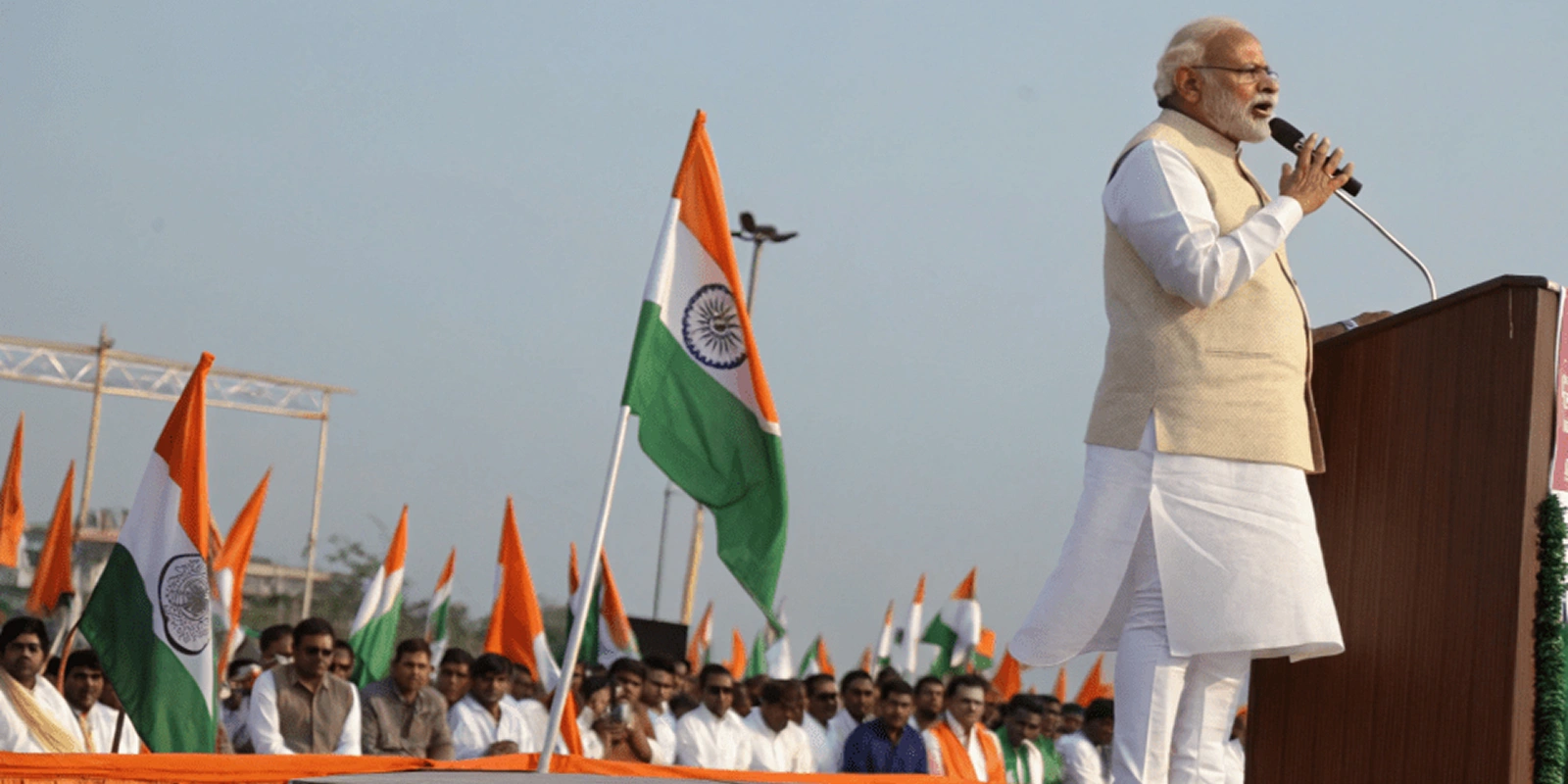 Leader addressing crowd with Indian flags, symbolizing Dighe Saheb’s Hindutva voice inspiring Marathi pride and youth responsibility.